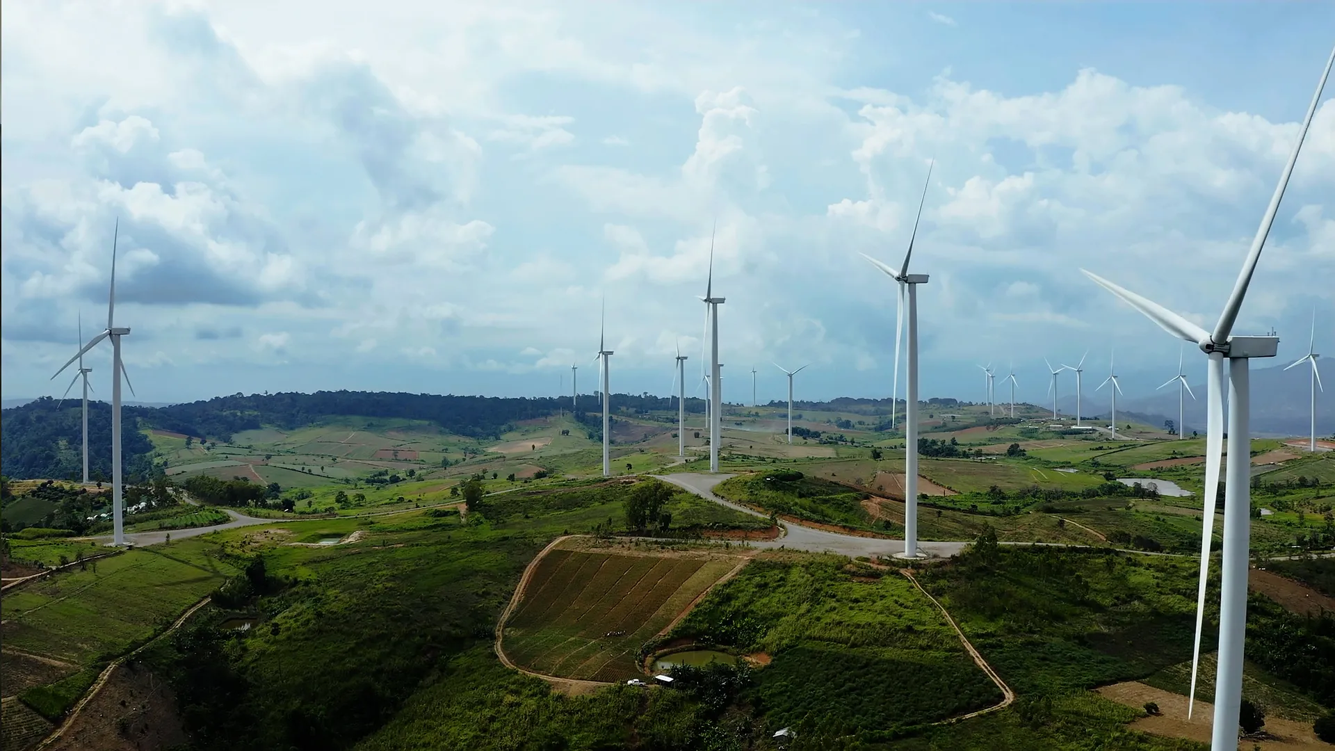 Visuel Sandvik montrant un parc éolien dans un paysage vallonné, illustrant les produits et services industriels liés aux énergies renouvelables