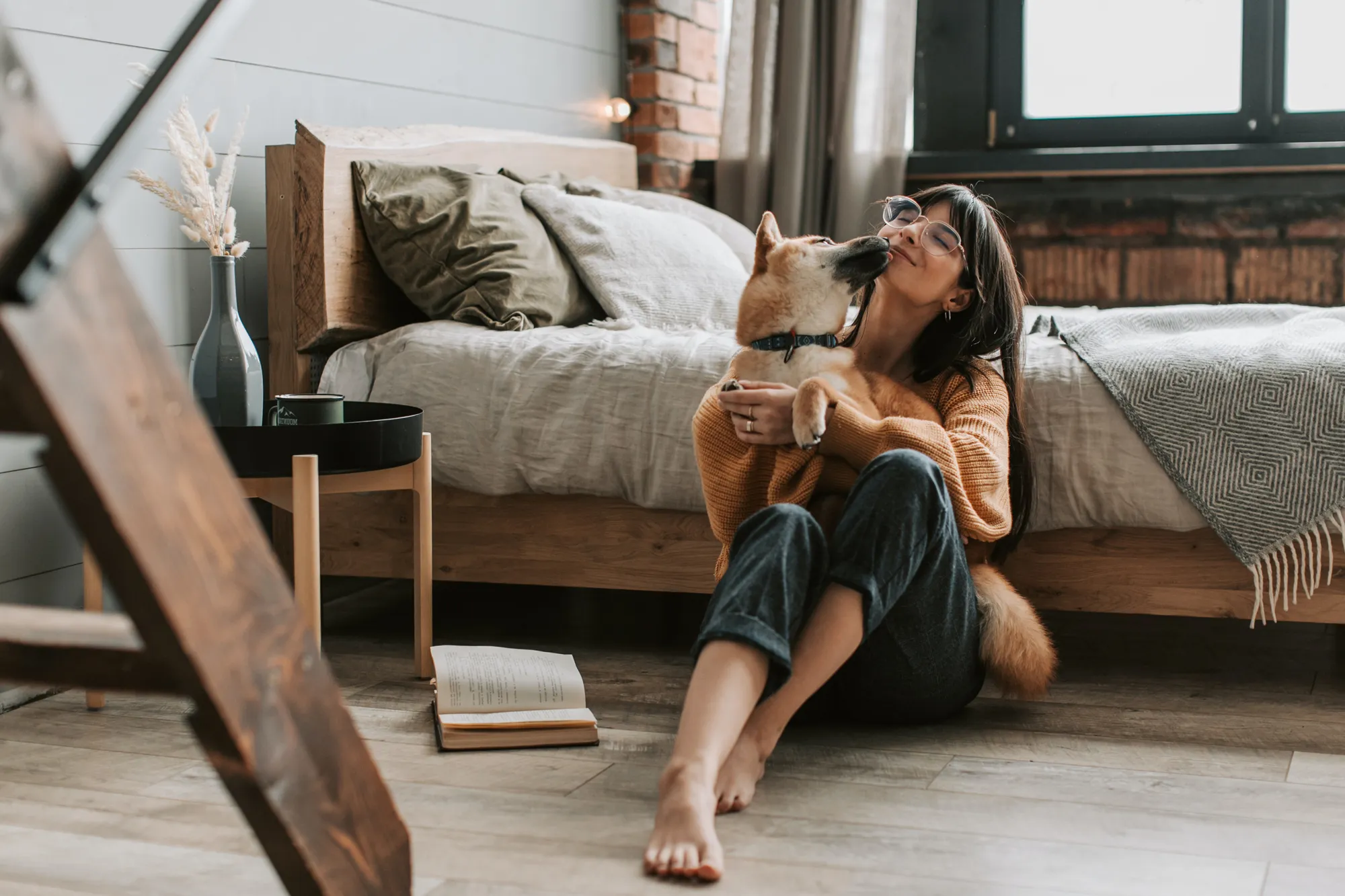 Visuel Goodflair pour assurance santé animale, montrant une femme assise dans une chambre avec son chien dans une ambiance chaleureuse et rassurante
